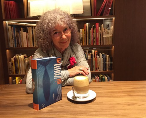 Joanika in de bibliotheek van het Ambassade Hotel in Amsterdam met het boek van Paul Smit